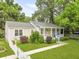 Landscaped single-story home with a cheerful yellow door, inviting front porch, and a picket fence at 2343 Herndon Dr, Charleston, SC 29414