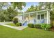 Charming home with a cheerful yellow door, inviting covered porch with blue accents, and manicured landscaping at 2343 Herndon Dr, Charleston, SC 29414