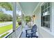 Inviting covered front porch with blue-painted floor, wicker seating, and a glimpse of lush yard at 2343 Herndon Dr, Charleston, SC 29414