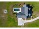Expansive aerial view showcasing modern home, pool, and firepit surrounded by lush green lawns at 2621 Anchor Watch Dr, Wadmalaw Island, SC 29487