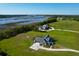 Stunning aerial view of two luxury homes on a vast green lawn, surrounded by marsh and waterfront views at 2621 Anchor Watch Dr, Wadmalaw Island, SC 29487
