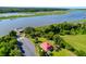 Aerial view features a charming home, manicured lawn, waterway and dock, all surrounded by lush greenery at 2621 Anchor Watch Dr, Wadmalaw Island, SC 29487