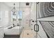 A bright bathroom with a glass shower and soaking tub beneath bright windows and a wood art piece at 2621 Anchor Watch Dr, Wadmalaw Island, SC 29487