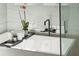 Close up of a tub with marble surround, a plant, and black plumbing fixtures in this bathroom at 2621 Anchor Watch Dr, Wadmalaw Island, SC 29487