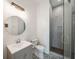 Contemporary bathroom featuring a glass enclosed shower, round mirror, and black and white patterned tile at 2621 Anchor Watch Dr, Wadmalaw Island, SC 29487