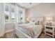 A serene bedroom with a cozy bed, soft lighting, and a view to a lush landscape through bright windows at 2621 Anchor Watch Dr, Wadmalaw Island, SC 29487