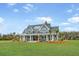 Charming two-story home with a spacious porch, rocking chairs, and meticulous landscaping at 2621 Anchor Watch Dr, Wadmalaw Island, SC 29487