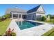Backyard view of a gray home with a covered patio, swimming pool and lush lawn at 2621 Anchor Watch Dr, Wadmalaw Island, SC 29487