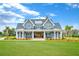 Charming front exterior featuring a manicured lawn, a welcoming porch, and double-door entry at 2621 Anchor Watch Dr, Wadmalaw Island, SC 29487