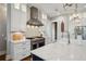 A chef's kitchen features white cabinets, a marble countertop island, and stainless steel oven with a herringbone backsplash at 2621 Anchor Watch Dr, Wadmalaw Island, SC 29487