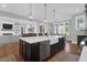 Well-lit kitchen featuring a dark island with seating, modern appliances, and open concept design at 2621 Anchor Watch Dr, Wadmalaw Island, SC 29487