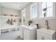 Laundry room features a utility sink, built-in shelving, front loading appliances, and neutral decor at 2621 Anchor Watch Dr, Wadmalaw Island, SC 29487