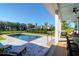 Covered patio overlooking the pool, with lounge chairs, dining table and serene backyard view at 2621 Anchor Watch Dr, Wadmalaw Island, SC 29487