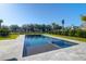 Backyard view of a modern pool, well-manicured lawn and distant trees creating a peaceful setting at 2621 Anchor Watch Dr, Wadmalaw Island, SC 29487