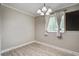 An empty bedroom featuring wood-look flooring, a window with curtains, and a modern chandelier at 2702 Decatur St, North Charleston, SC 29405