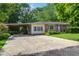 View of a single-story home with driveway and carport nestled among mature trees at 2903 Shadow Ln, North Charleston, SC 29406