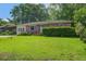 Quaint single-story home with vibrant green lawn and lush landscaping enhancing its curb appeal at 2903 Shadow Ln, North Charleston, SC 29406