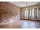 Empty living room featuring brick wall, wood floors and natural light at 2903 Shadow Ln, North Charleston, SC 29406