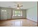 Bright living room with hardwood floors, ceiling fan, and natural light from the large window at 2903 Shadow Ln, North Charleston, SC 29406