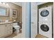Well-lit bathroom area featuring a stackable washer/dryer, vanity, and toilet; maximizes space and functionality at 2942 Atrium Villa Dr # 42, Johns Island, SC 29455