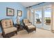 Comfortable bedroom features blue walls, balcony access, and wicker chairs creating a peaceful space with beautiful views at 2942 Atrium Villa Dr # 42, Johns Island, SC 29455