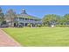 Spacious backyard with a manicured lawn, brick pathway, mature trees, and a glimpse of the waterfront at 3125 Sturbridge Rd, Mount Pleasant, SC 29466
