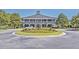 Beautiful clubhouse featuring a brick facade, columned verandas, lush landscaping, and a circular driveway entrance at 3125 Sturbridge Rd, Mount Pleasant, SC 29466