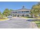 Grand clubhouse featuring a brick facade, columned verandas, lush landscaping, and a circular driveway entrance at 3125 Sturbridge Rd, Mount Pleasant, SC 29466