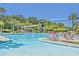 Resort-style community pool featuring a waterslide, tower, palm trees, lounge chairs, and lush landscaping for relaxation at 3125 Sturbridge Rd, Mount Pleasant, SC 29466