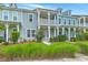 Inviting townhomes displaying colorful facades, second story porches, and meticulously maintained landscaping at 3125 Sturbridge Rd, Mount Pleasant, SC 29466