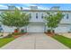 Charming townhome showcasing a two-car garage, attractive landscaping, and a concrete driveway at 3125 Sturbridge Rd, Mount Pleasant, SC 29466