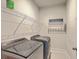 Well-lit laundry room features a washer and dryer, overhead shelving, and charming wall decor at 3125 Sturbridge Rd, Mount Pleasant, SC 29466