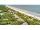 Breathtaking aerial view of townhouses nestled between vibrant green trees and a serene sandy beach at 3560 Shipwatch Rd, Kiawah Island, SC 29455
