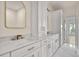 Bathroom boasts double sinks, white cabinetry, gold fixtures, marble countertops, and neutral paint at 3560 Shipwatch Rd, Kiawah Island, SC 29455