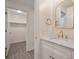 Bathroom featuring a marble countertop vanity with gold fixtures and view into an organized closet at 3560 Shipwatch Rd, Kiawah Island, SC 29455