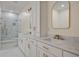 Bathroom boasts double sinks, white cabinetry, gold fixtures, marble countertops, and walk-in shower at 3560 Shipwatch Rd, Kiawah Island, SC 29455