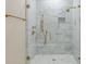 This stunning shower features a glass door, sleek gray tiling, and elegant gold fixtures at 3560 Shipwatch Rd, Kiawah Island, SC 29455