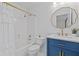Charming bathroom features a vanity with a blue base, gold fixtures, and a shower with a white curtain at 3685 Colonel Vanderhorst Cir, Mount Pleasant, SC 29466