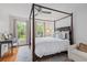 Light-filled bedroom featuring a four-poster bed, desk area, and large windows offering outdoor views at 3685 Colonel Vanderhorst Cir, Mount Pleasant, SC 29466