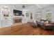 Inviting living room with a fireplace, built-in shelving, hardwood floors, and large windows at 3685 Colonel Vanderhorst Cir, Mount Pleasant, SC 29466
