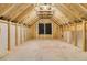 Unfinished attic space with exposed wood framing and a window, offering potential for customization at 395 Wappoo Trace Ln, Summerville, SC 29486
