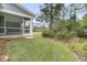 Green backyard featuring a screened-in porch and lush landscaping for privacy and relaxation at 395 Wappoo Trace Ln, Summerville, SC 29486