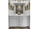 Bathroom with dual sinks, white cabinets, a large mirror, modern lighting, and a tiled shower at 432 Caledon Ct, Johns Island, SC 29455