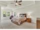 Well-lit main bedroom featuring tray ceilings, ceiling fan, and large windows at 466 Gianna Ln, Goose Creek, SC 29445