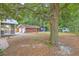 Backyard with mature shade trees, brick patio, detached garage, and screened in porch at 4729 Lang Ridge Dr, North Charleston, SC 29405