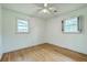 Bright bedroom featuring a ceiling fan, hardwood floors, and two windows letting in natural light at 4729 Lang Ridge Dr, North Charleston, SC 29405