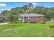 Quaint brick home featuring a well-manicured lawn and a vibrant blue front door at 4729 Lang Ridge Dr, North Charleston, SC 29405