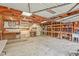 Well-lit garage interior, featuring workbenches, storage shelves, and open rafter ceiling at 4729 Lang Ridge Dr, North Charleston, SC 29405