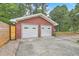 Detached two car garage constructed of red brick with white garage doors at 4729 Lang Ridge Dr, North Charleston, SC 29405