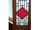 Close-up of a striking stained glass window featuring a diamond shape with red, white, and blue panes at 4729 Lang Ridge Dr, North Charleston, SC 29405